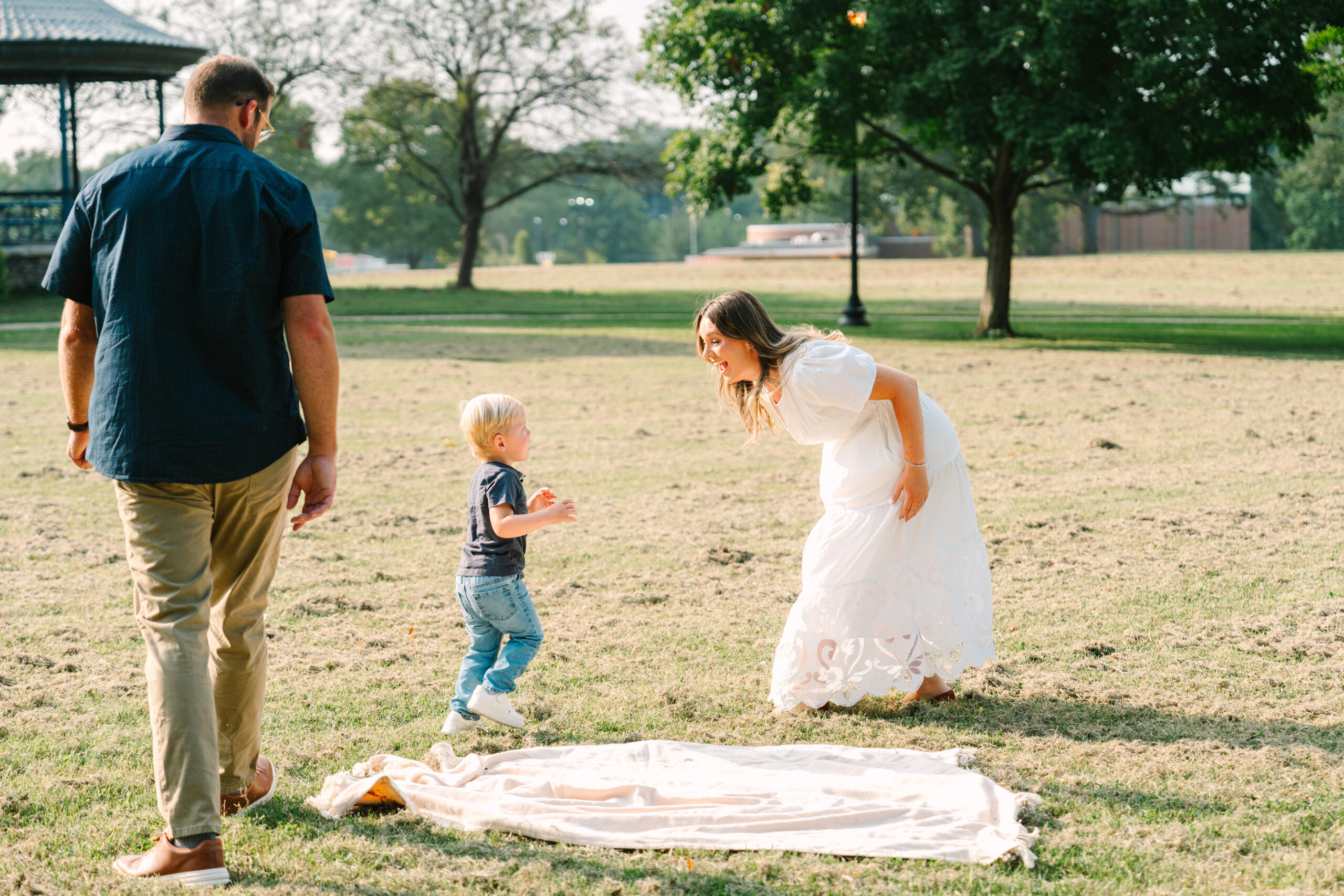 Family playing tag during outdoor photo session at a park in Evansville, Indiana by Brittney Moseby Photography